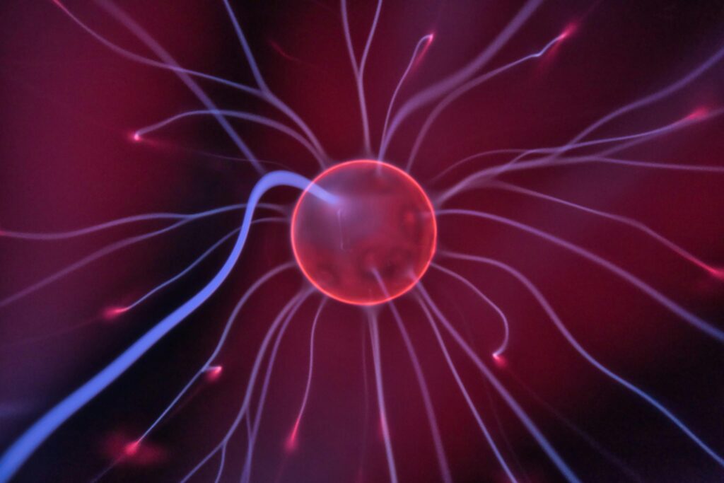 The Danger of Ignorance in a Science-Driven World Close-up of a glowing plasma ball with colorful electric currents reaching outwards.