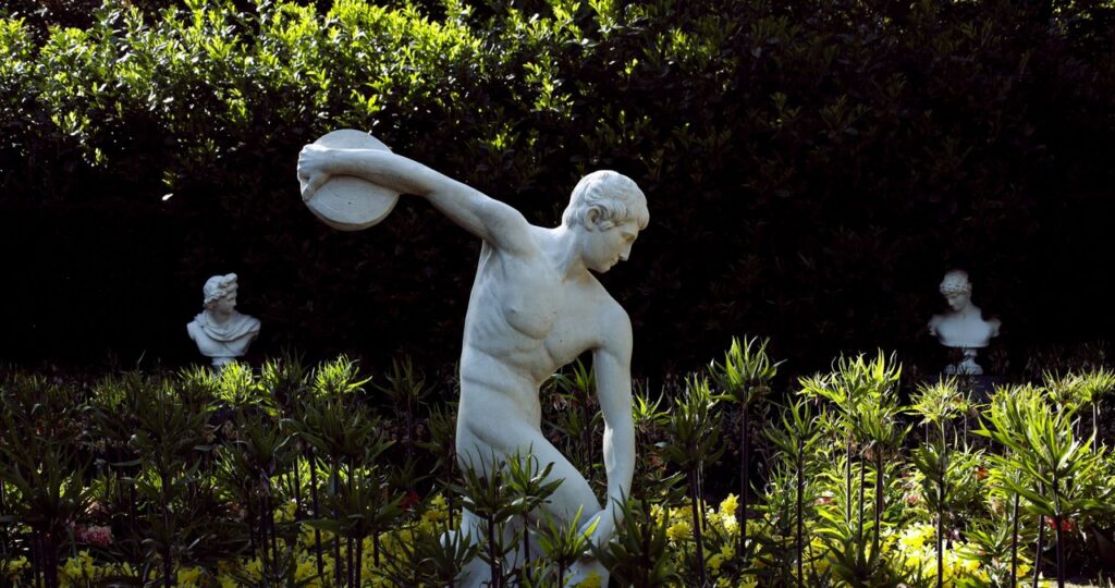 Sexual Energy: One of the Most Misunderstood Forces in Human Life Classic Discobolus statue amidst greenery, capturing timeless elegance of sculpture art.